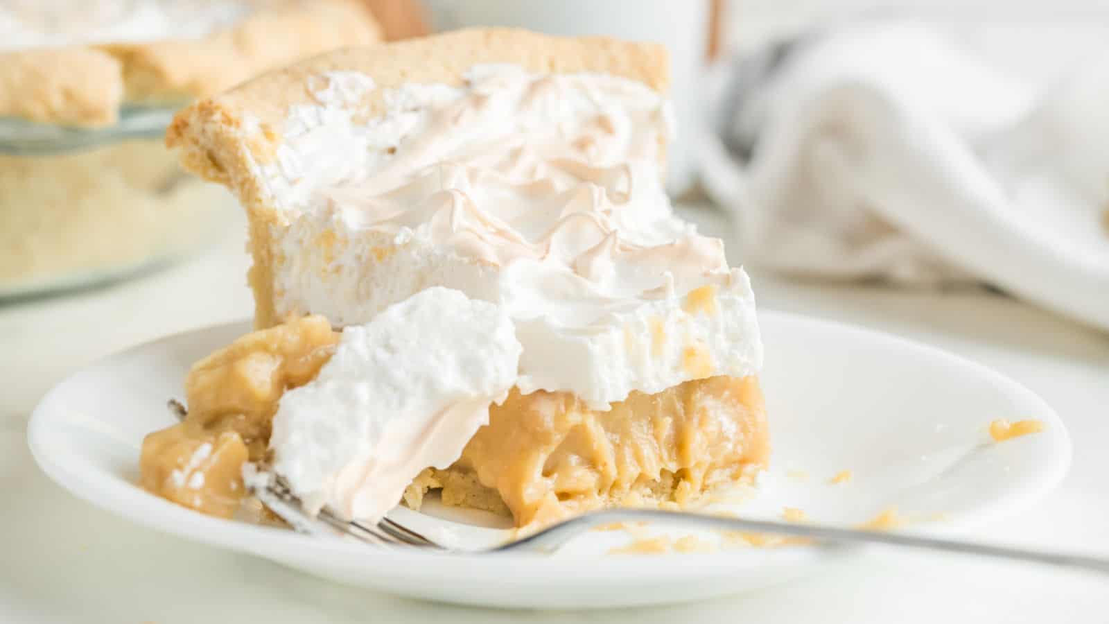 A butterscotch pie with meringue on a wire cooling rack.