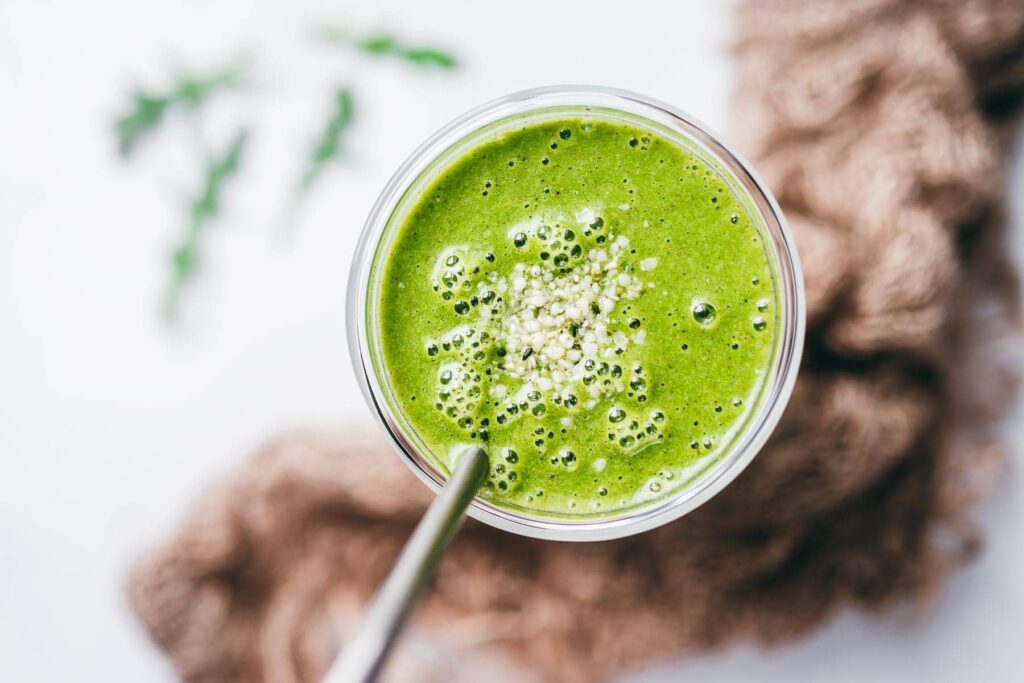 An overhead image of a green smoothie in a glass. 
