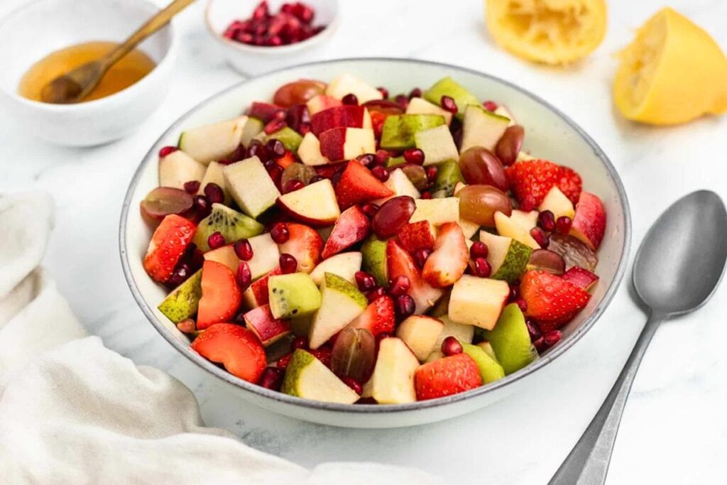 Fruit salad with mixed fresh berries, melon, and citrus in a bowl.