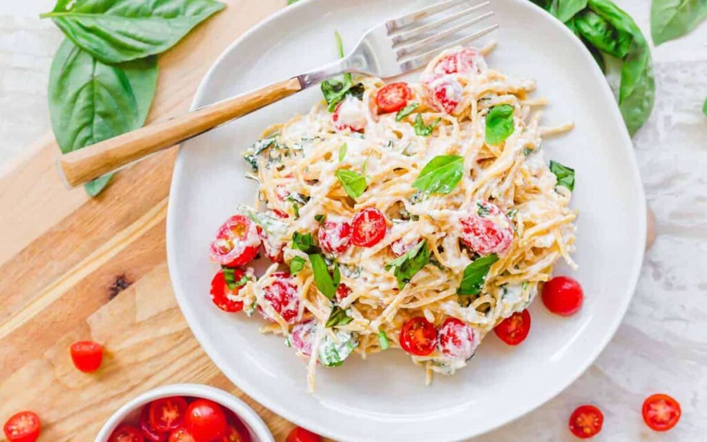 Creamy lemon ricotta pasta tossed with herbs and served in a shallow bowl.