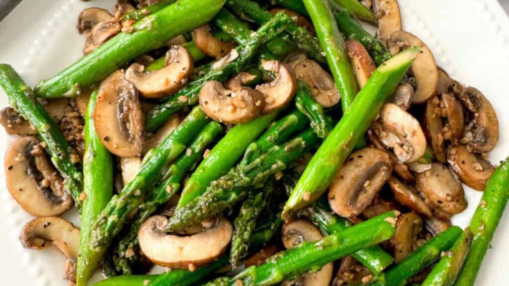 Sautéed asparagus and mushrooms cooked in a skillet with garlic and Asian seasonings.