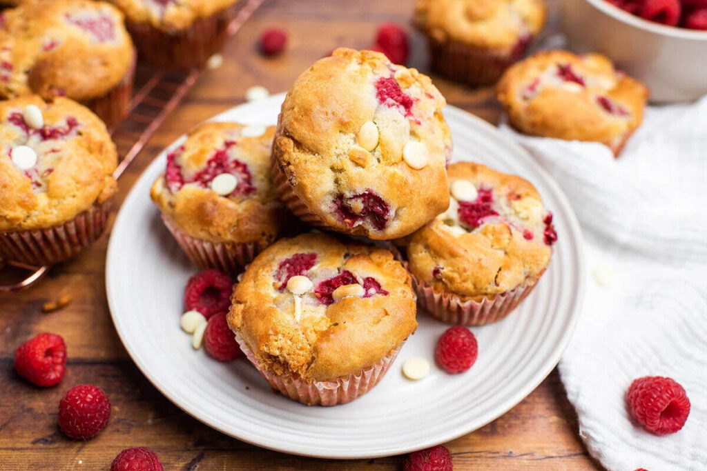 White chocolate raspberry muffins on a plate.