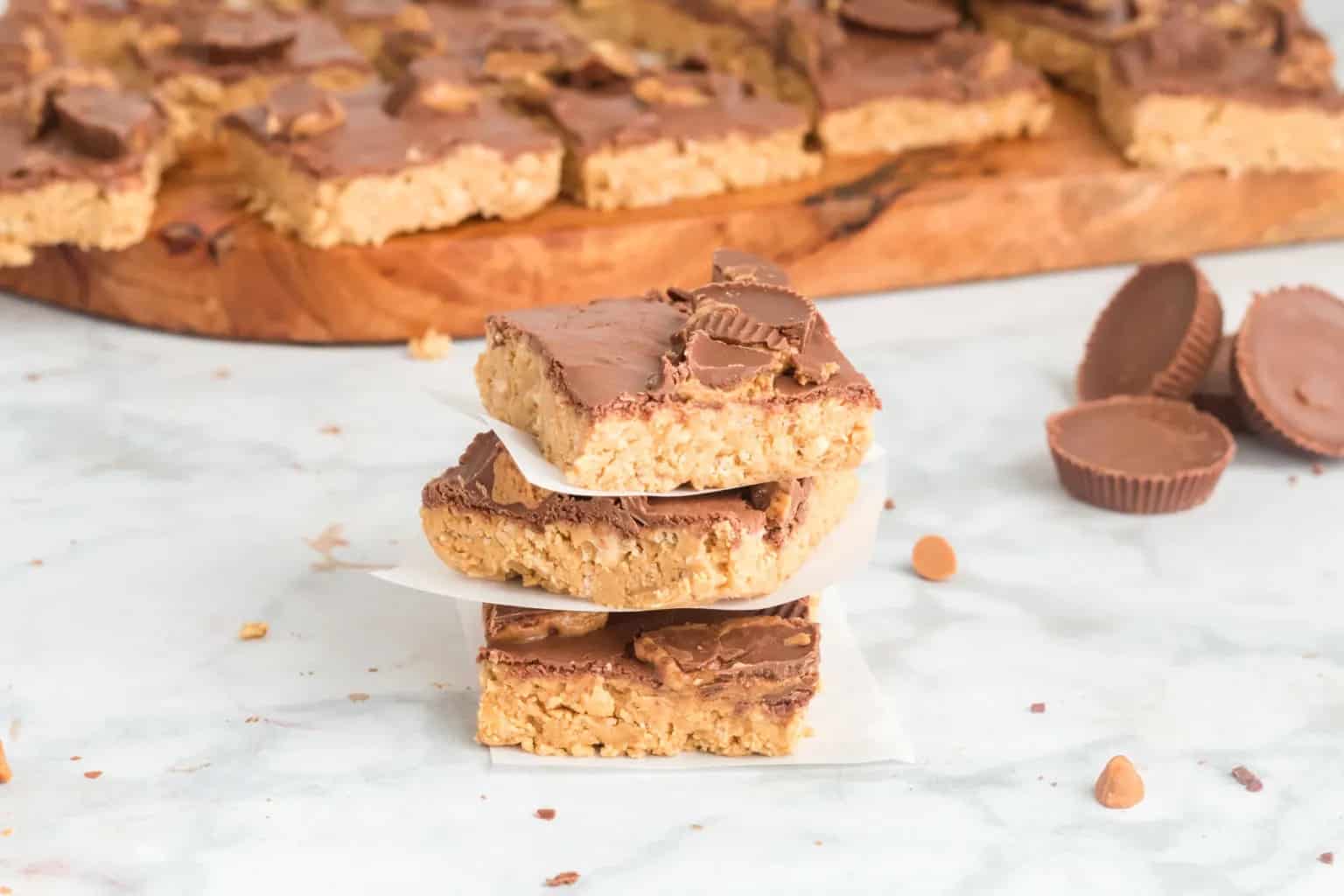 Stack of three crispy bars with the pan of dessert in the background.