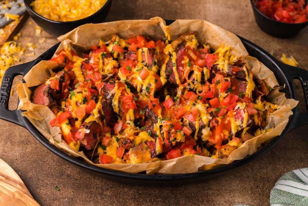 A casserole dish with steak loaded fries.