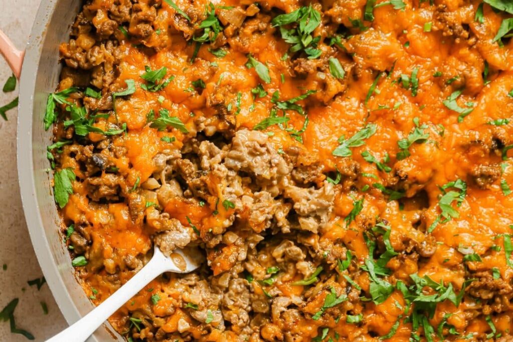 Creamy ground beef skillet with cauliflower rice with a wooden spoon.