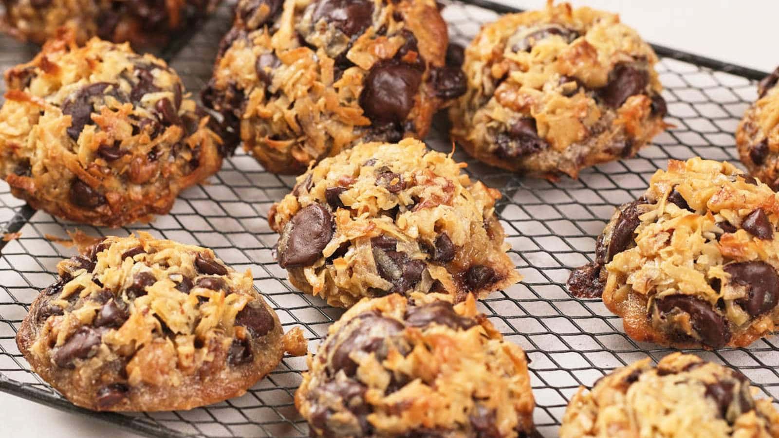 A cooling rack holds several magic cookies with a golden brown, crispy exterior.