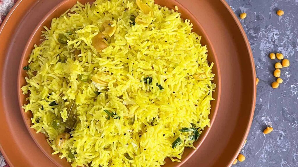 A clay bowl filled with Cabbage Rice garnished with nuts and herbs on a grey surface with scattered lentils.