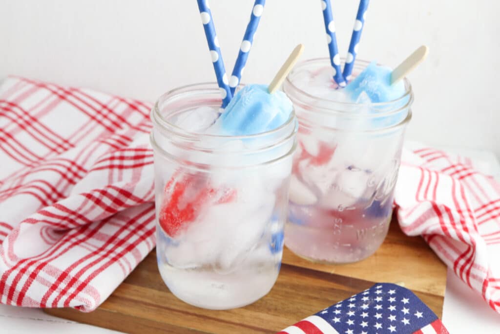 2 glasses of bomp pop mocktail on a wooden board.