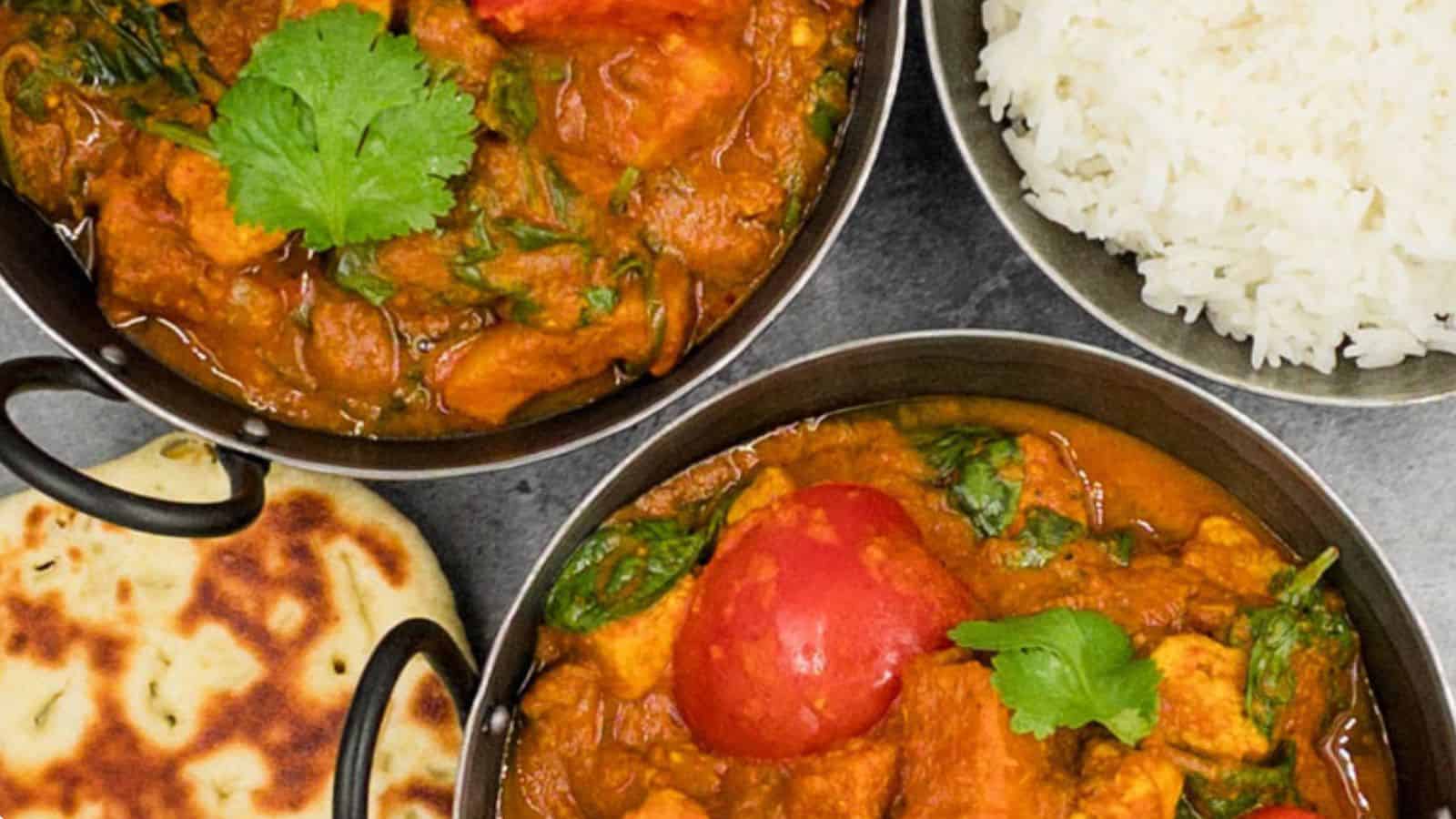 Three bowls of international potato  curry with rice and naan.