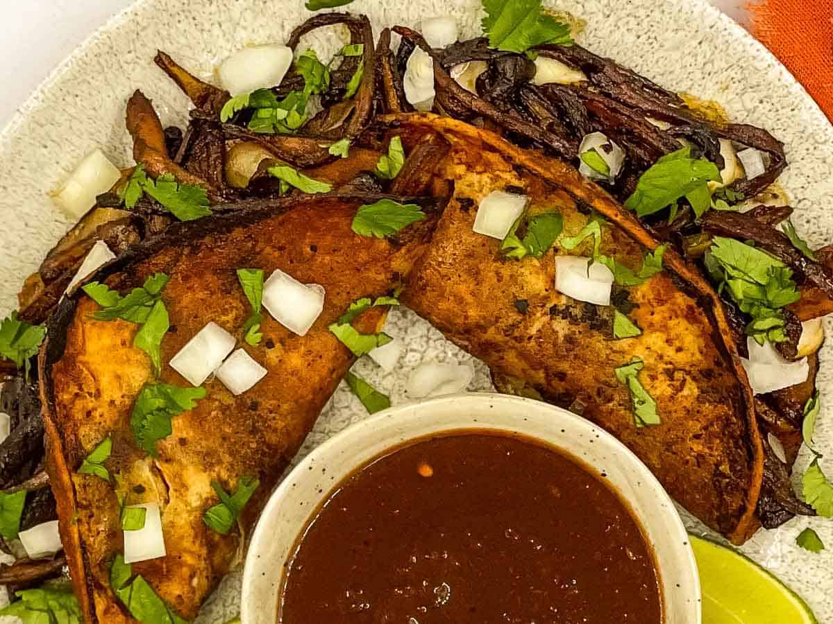 A plate of tacos with a sauce on it.