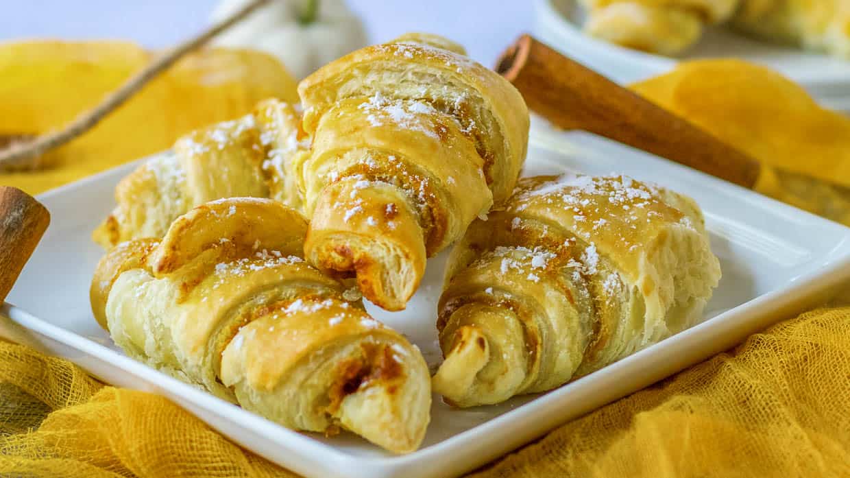 Pumpkin pie crescent rolls on a white plate.