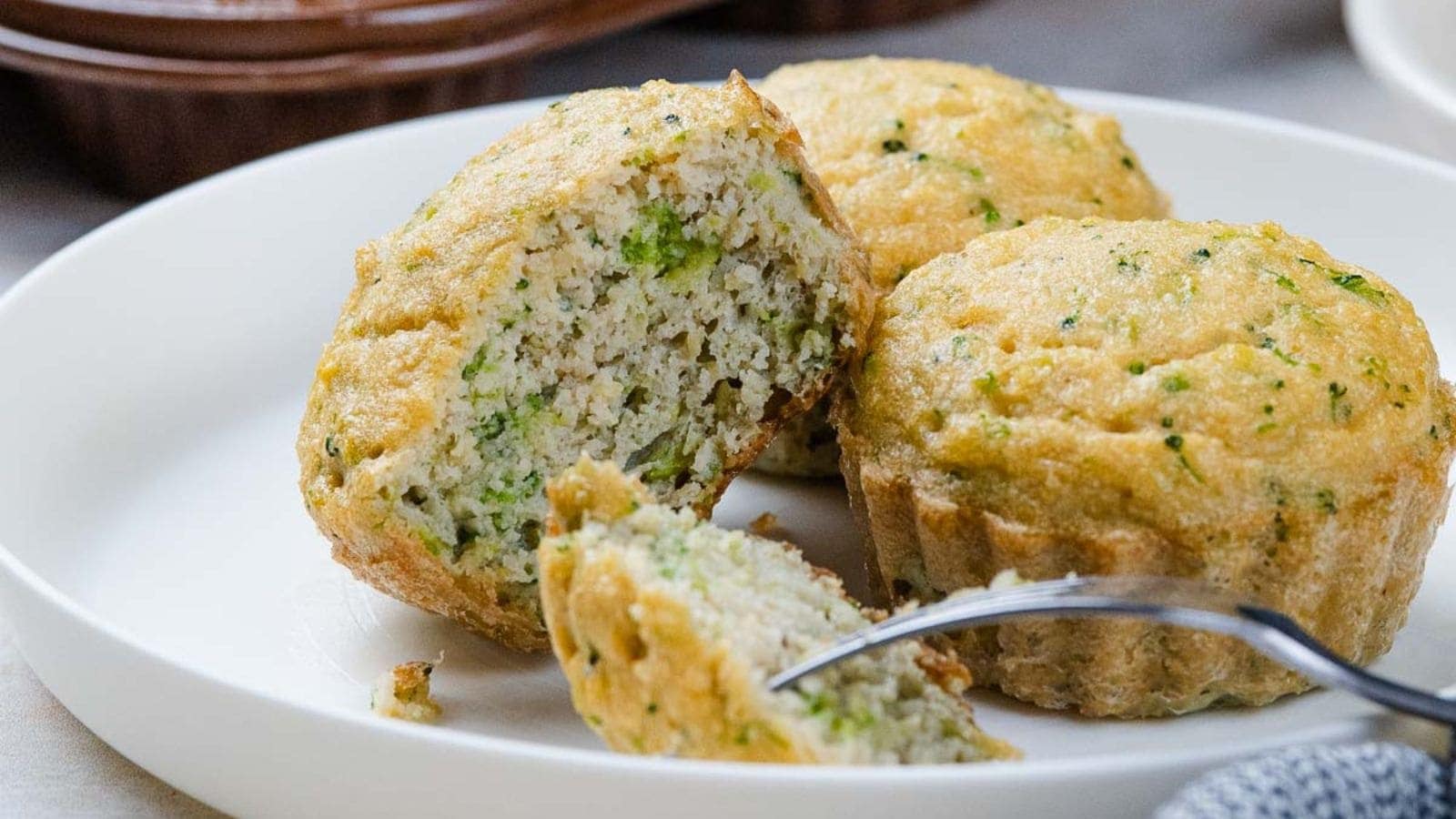 Tops of two savory muffins with hidden broccoli.